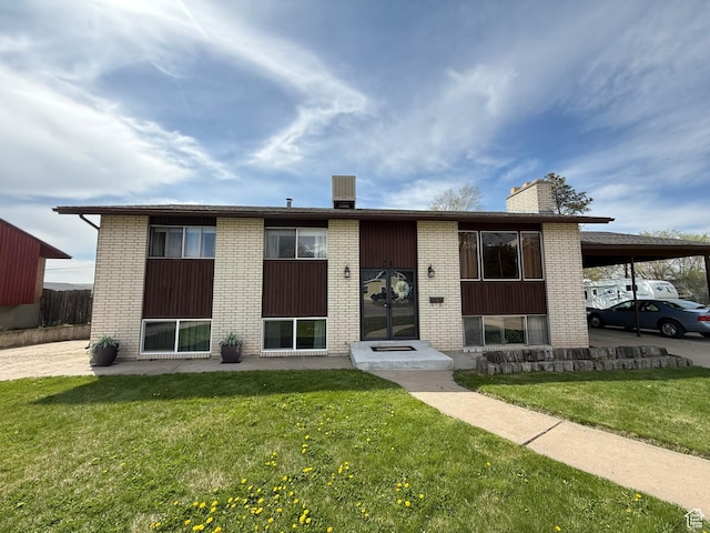 24 S 400 W, Kaysville, UT 84037 - view of front of house featuring a front yard, brick siding, a carport, and a chimney