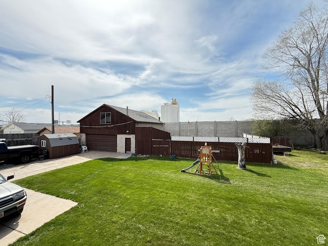 24 S 400 W, Kaysville, UT 84037 - view of yard with concrete driveway, an outbuilding, a garage, fence, and a playground