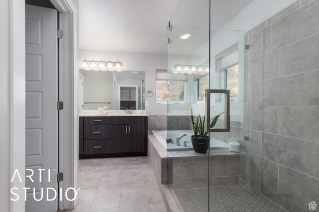 full bathroom featuring a tile shower, a garden tub, vanity, and tile patterned flooring