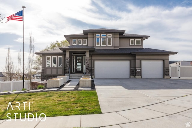 prairie-style home with concrete driveway, stucco siding, stone siding, a garage, and fence
