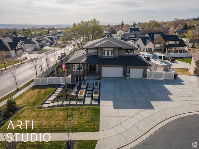 view of front of house with a garage, fence, a gate, driveway, and a residential view