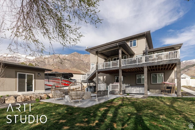back of house featuring a patio, stairs, stucco siding, and a lawn