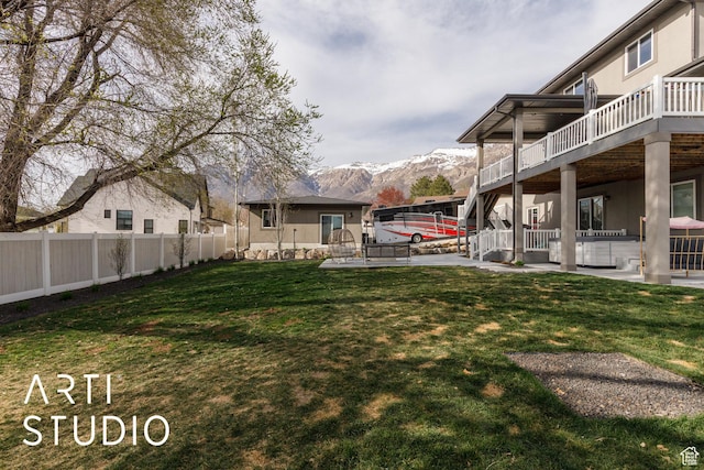 view of yard with a mountain view, a fenced backyard, and a patio