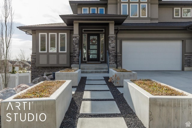 entrance to property with an attached garage, fence, stone siding, and driveway
