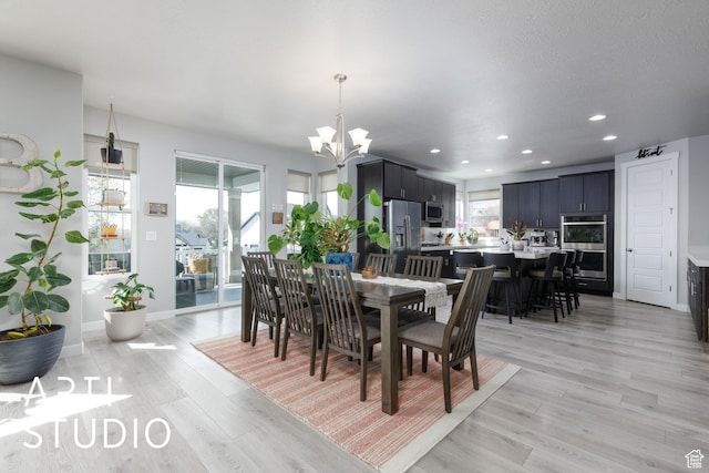 dining room with light wood-style flooring, a notable chandelier, baseboards, and recessed lighting
