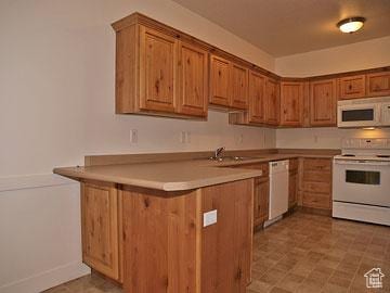 397 S State St Unit 33, Provo, UT 84606 - kitchen featuring white appliances, light countertops, brown cabinetry, and a peninsula