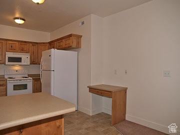 397 S State St Unit 33, Provo, UT 84606 - kitchen featuring white appliances, brown cabinets, and baseboards