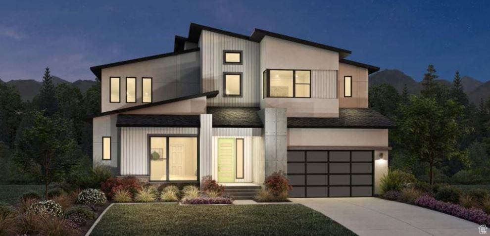 contemporary house with an attached garage, concrete driveway, and stucco siding