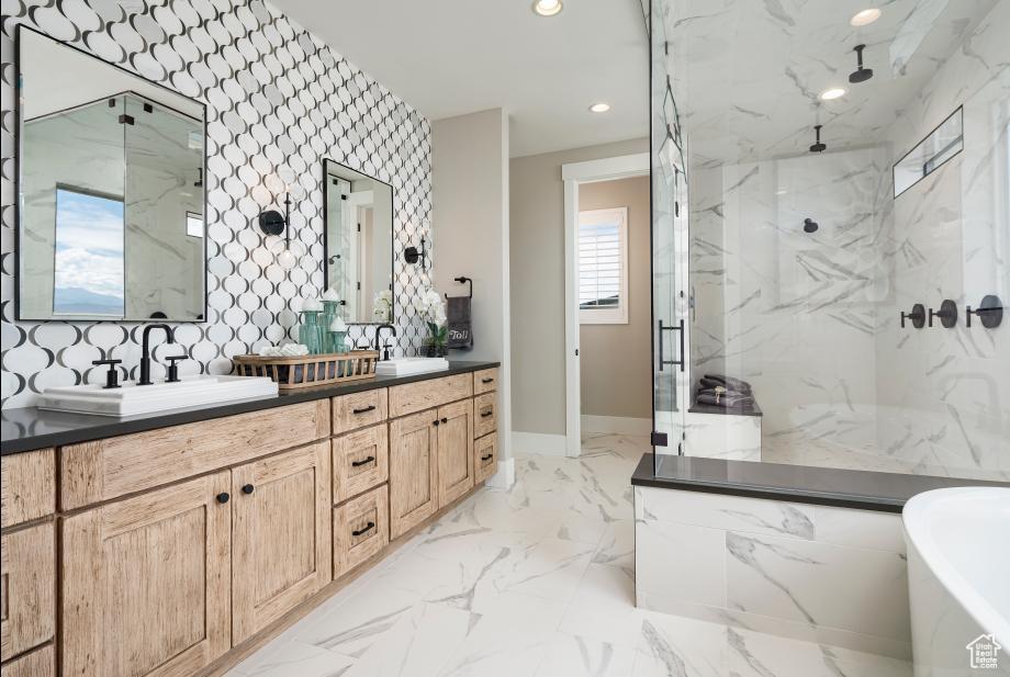 bathroom with a freestanding bath, recessed lighting, a sink, and a marble finish shower