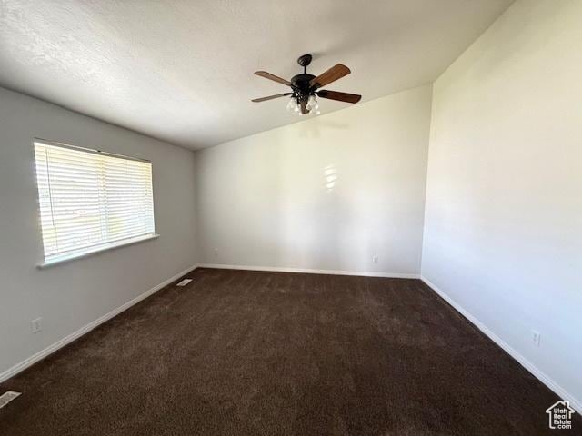 carpeted spare room featuring ceiling fan and baseboards