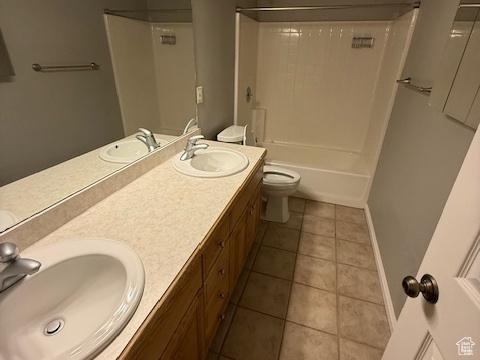 bathroom with double vanity, a sink, and toilet