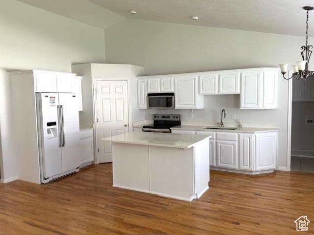 kitchen with a sink, appliances with stainless steel finishes, white cabinets, and high vaulted ceiling