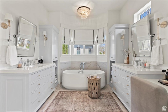 bathroom with a wealth of natural light, a freestanding bath, and a sink