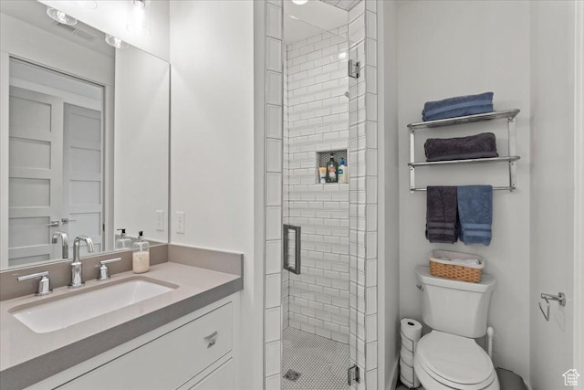bathroom featuring toilet, vanity, and a stall shower
