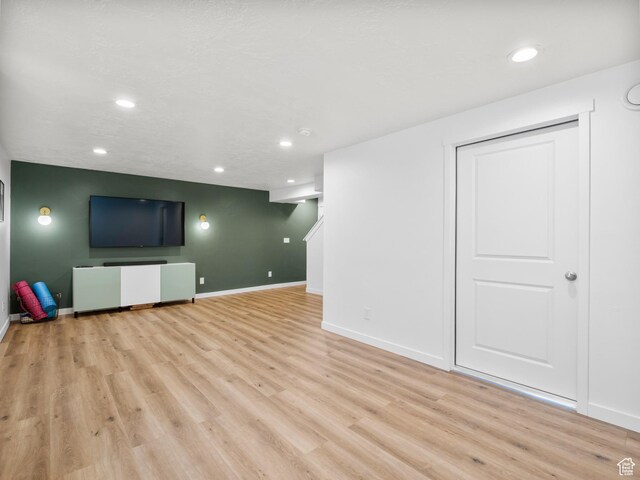 finished basement featuring light wood finished floors, baseboards, and recessed lighting