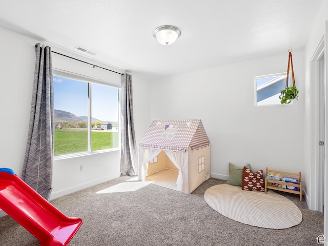 game room with baseboards, plenty of natural light, and carpet