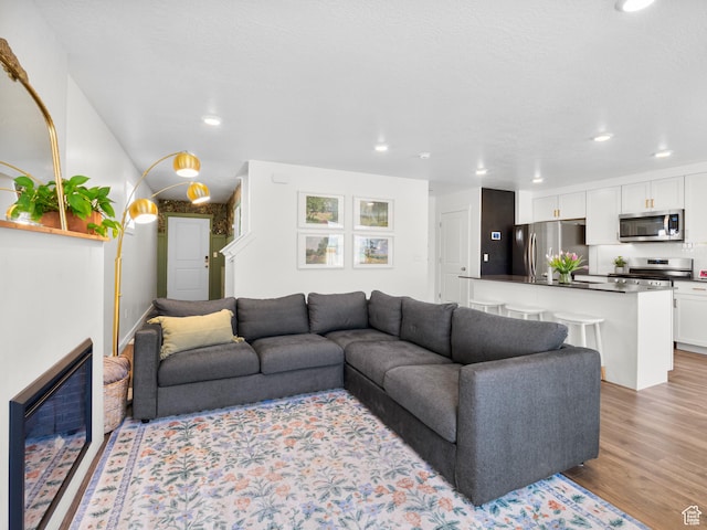 living room featuring light wood-style flooring and recessed lighting