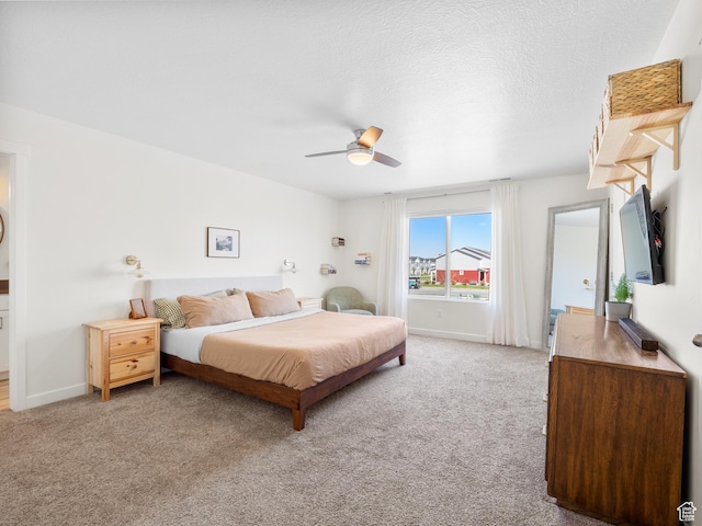 bedroom featuring light colored carpet, baseboards, and a ceiling fan