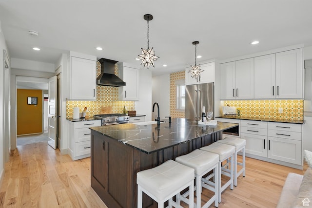 1148 E Kensington Ave, Salt Lake City, UT 84105 - kitchen with wall chimney range hood, tasteful backsplash, a breakfast bar, and high end appliances