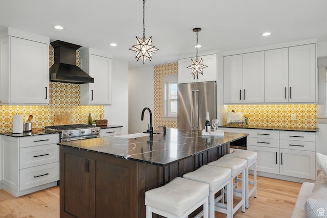 1148 E Kensington Ave, Salt Lake City, UT 84105 - kitchen featuring light wood-style floors, a sink, wall chimney exhaust hood, and stainless steel appliances