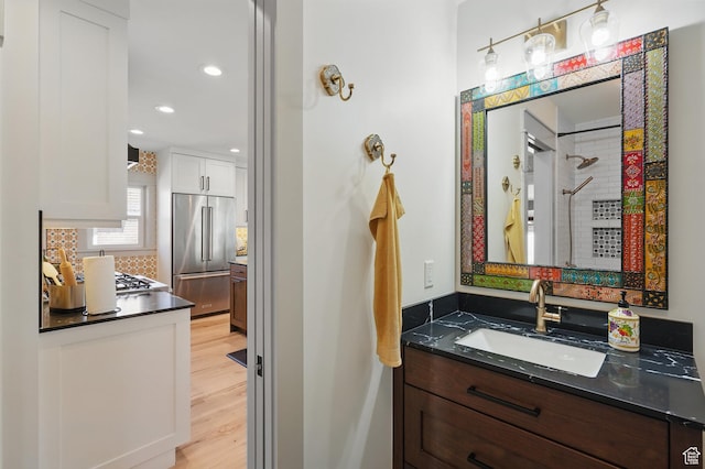 1148 E Kensington Ave, Salt Lake City, UT 84105 - bathroom featuring decorative backsplash, recessed lighting, vanity, and wood finished floors