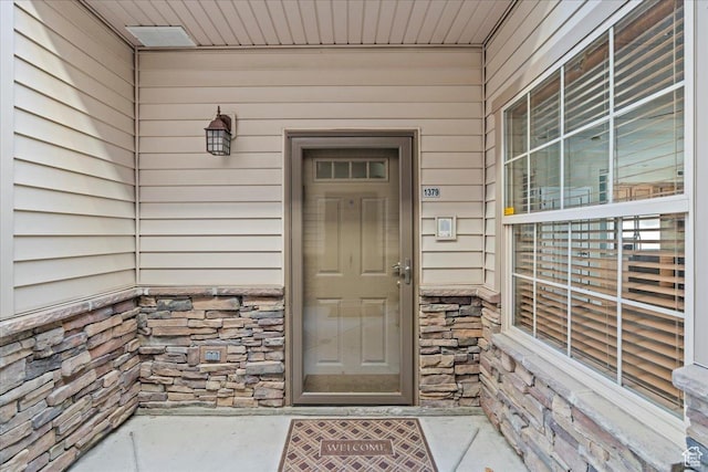 property entrance featuring stone siding