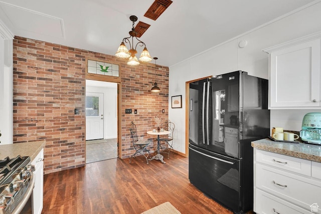 408 E 1700 S, Salt Lake City, UT 84115 - kitchen with freestanding refrigerator, stainless steel range with gas stovetop, white cabinetry, brick wall, and dark wood-style floors
