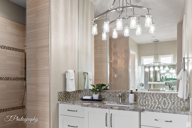bathroom featuring tiled shower, vanity, a chandelier, and tasteful backsplash
