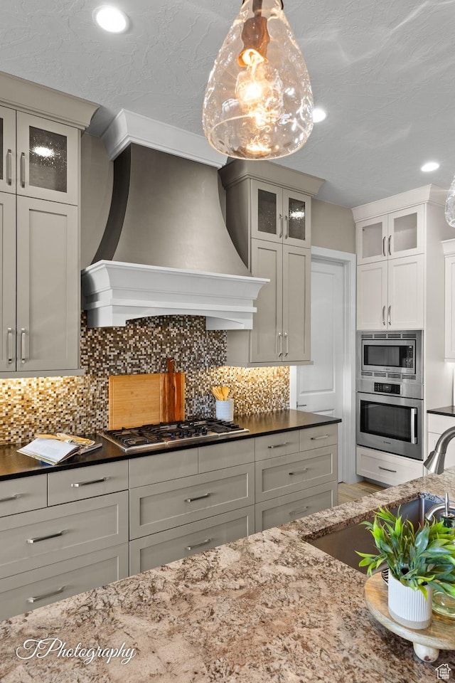 kitchen featuring tasteful backsplash, appliances with stainless steel finishes, and custom range hood