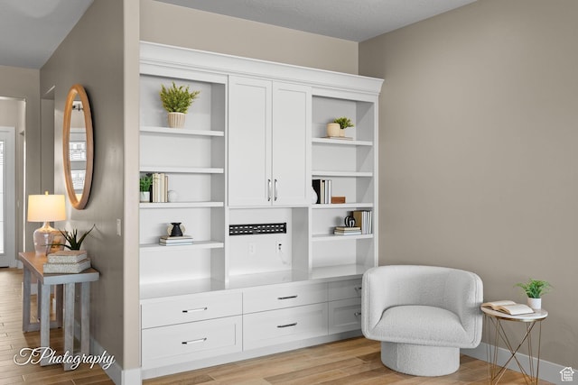 living area featuring light wood-style flooring and baseboards