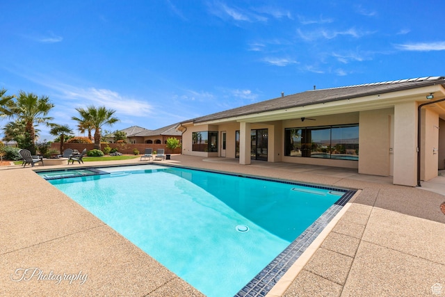 view of swimming pool featuring fence, a pool with connected hot tub, and a patio