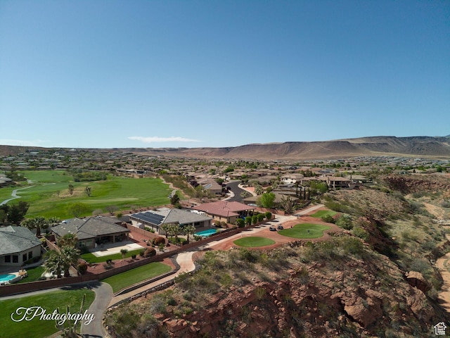 drone / aerial view featuring a mountain view, golf course view, and a residential view