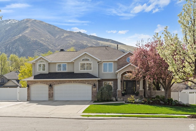 traditional-style house with a gate, driveway, a front yard, brick siding, and fence