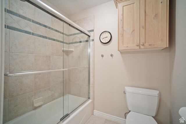 1778 E Indian Wells Ln, Draper, UT 84020 - full bath with tile patterned floors, toilet, baseboards, and shower / bath combination with glass door
