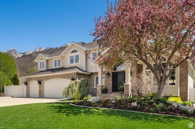 1778 E Indian Wells Ln, Draper, UT 84020 - traditional home with fence, concrete driveway, brick siding, a front lawn, and stucco siding