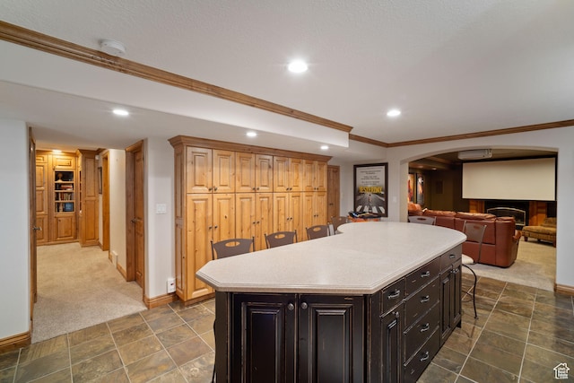 1778 E Indian Wells Ln, Draper, UT 84020 - kitchen with arched walkways, a kitchen island, light countertops, a breakfast bar area, and baseboards