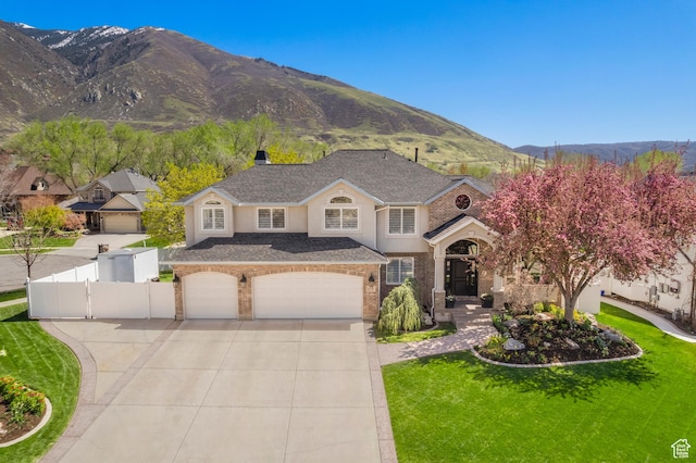 1778 E Indian Wells Ln, Draper, UT 84020 - traditional home with a mountain view, fence, concrete driveway, a front lawn, and a gate