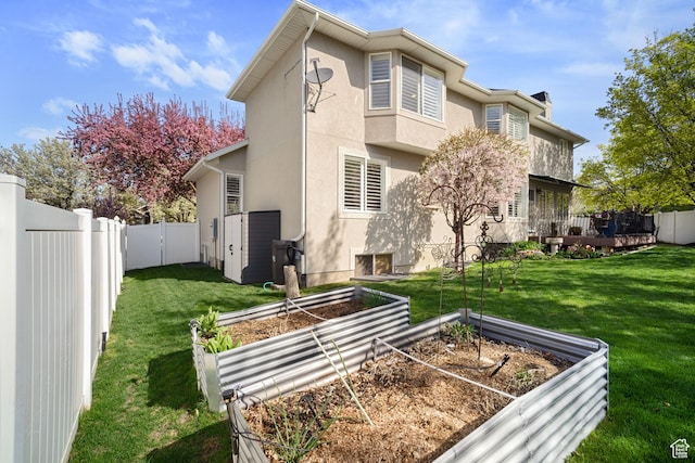 1778 E Indian Wells Ln, Draper, UT 84020 - back of house with a garden, stucco siding, a fenced backyard, and a lawn