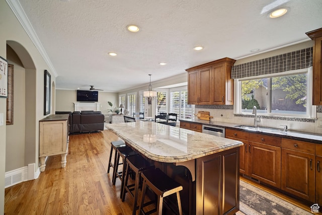 1778 E Indian Wells Ln, Draper, UT 84020 - kitchen featuring a center island, crown molding, dark stone counters, light wood finished floors, and a sink