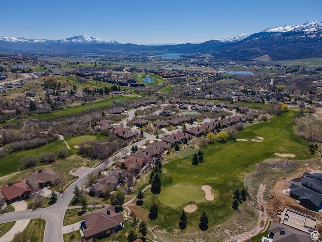 drone / aerial view with a mountain view, view of golf course, and a residential view