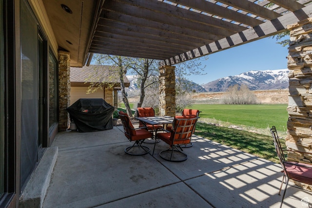 view of patio / terrace featuring a grill, outdoor dining space, a pergola, and a mountain view