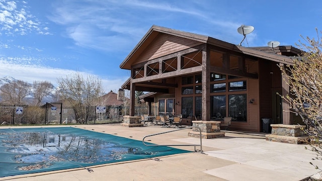 pool with a patio area and fence
