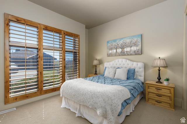 carpeted bedroom with visible vents and multiple windows