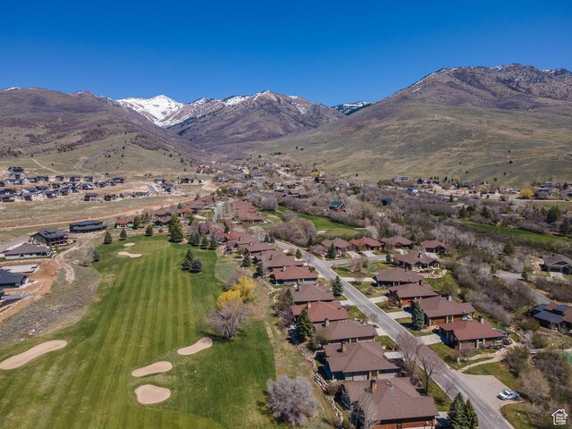 drone / aerial view with golf course view, a mountain view, and a residential view