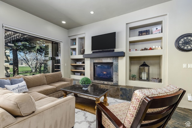 living area with a tiled fireplace, built in shelves, recessed lighting, and baseboards