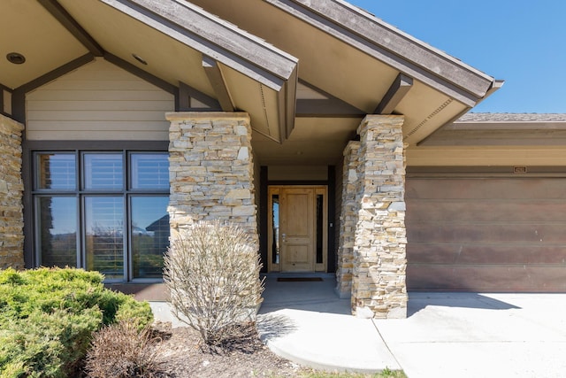 property entrance with an attached garage and stone siding