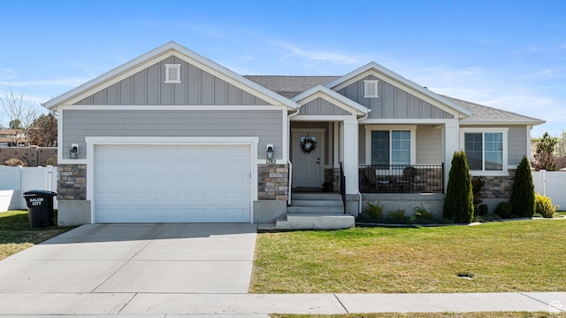 craftsman-style house featuring a garage, board and batten siding, stone siding, and concrete driveway