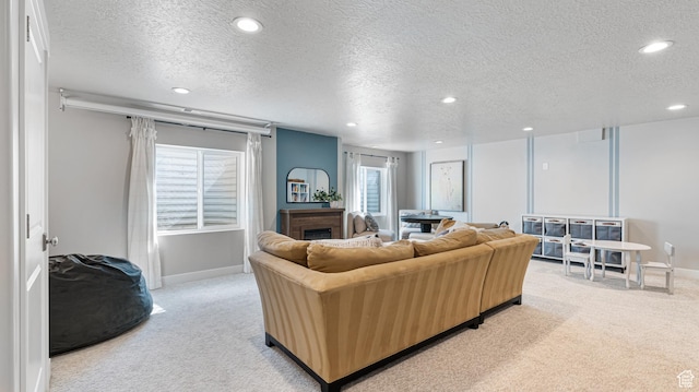 living area featuring light carpet, recessed lighting, a textured ceiling, and baseboards