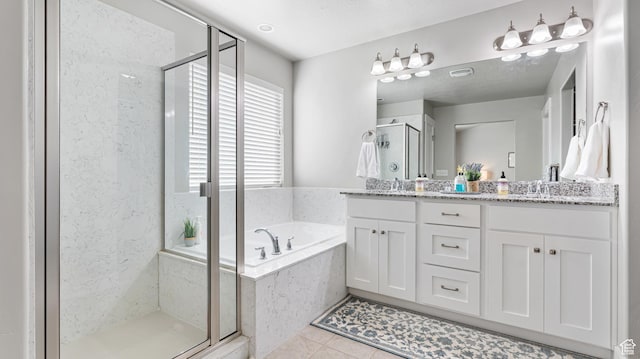 full bathroom featuring a sink, double vanity, tile patterned flooring, a stall shower, and a garden tub