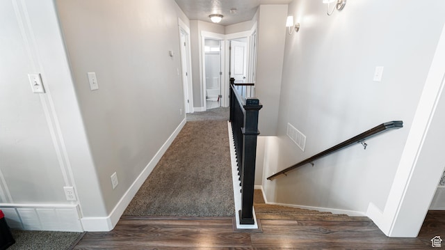 stairs with wood finished floors, baseboards, and visible vents
